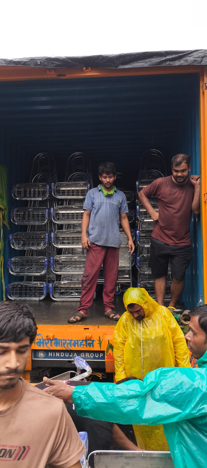 Perfecctio Enterprises team loading airport trolleys into Hinduja Group container truck